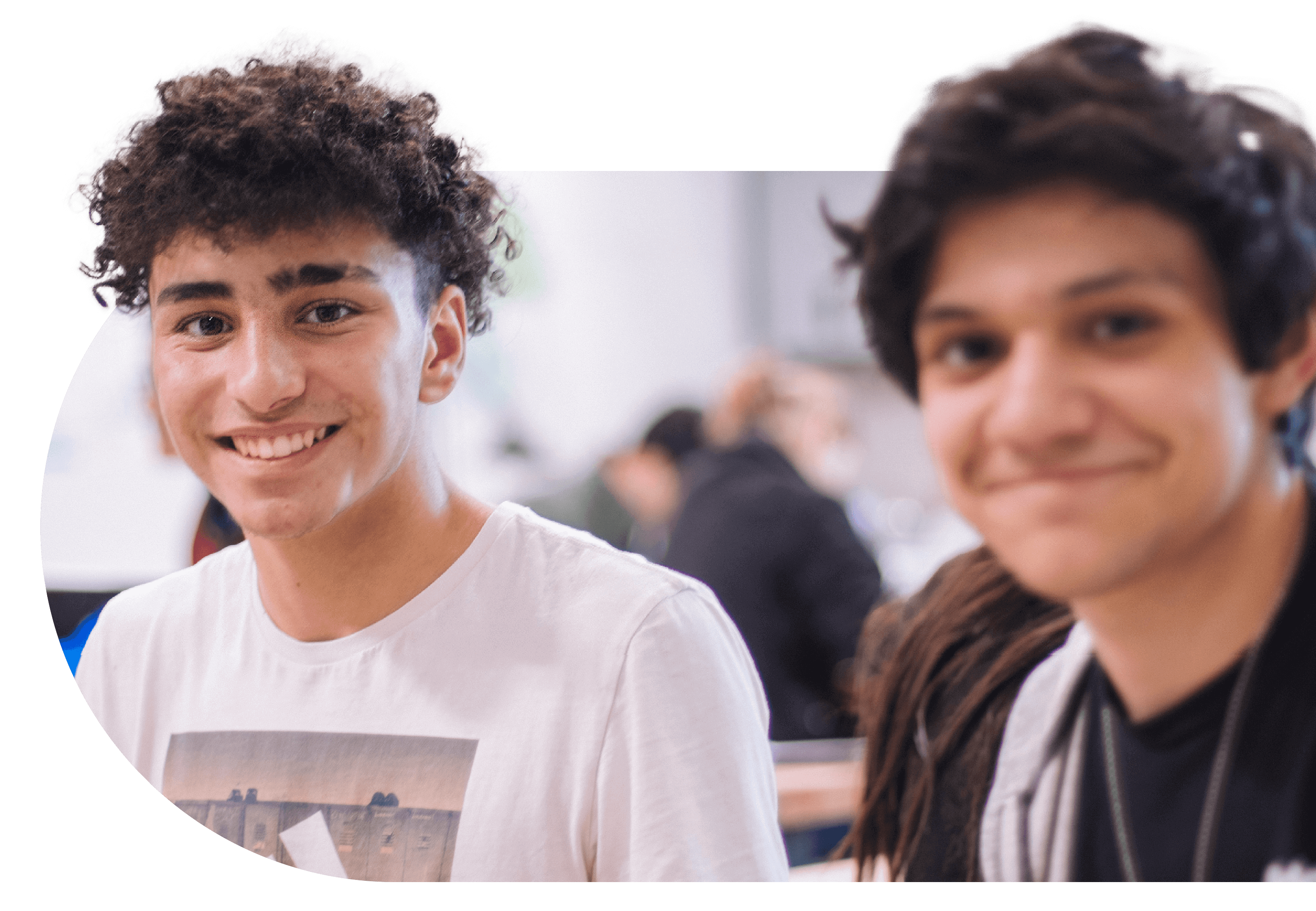two young men in a classroom smiling